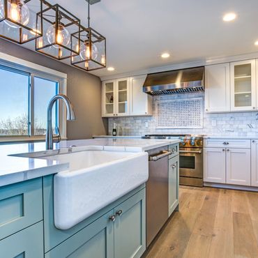 Modern kitchen with blue island and farmhouse sink.