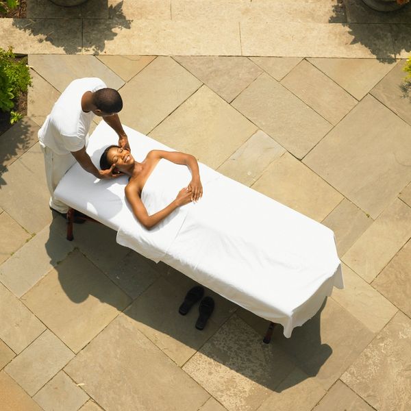 Woman receiving a relaxing outdoor massage on a sunny day.