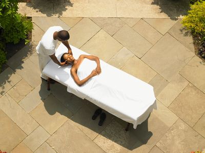 Woman receiving a relaxing outdoor massage on a sunny day.