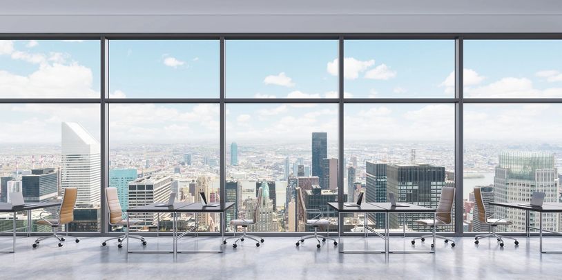 An empty office building with a panoramic view of the business sector of the city through windows