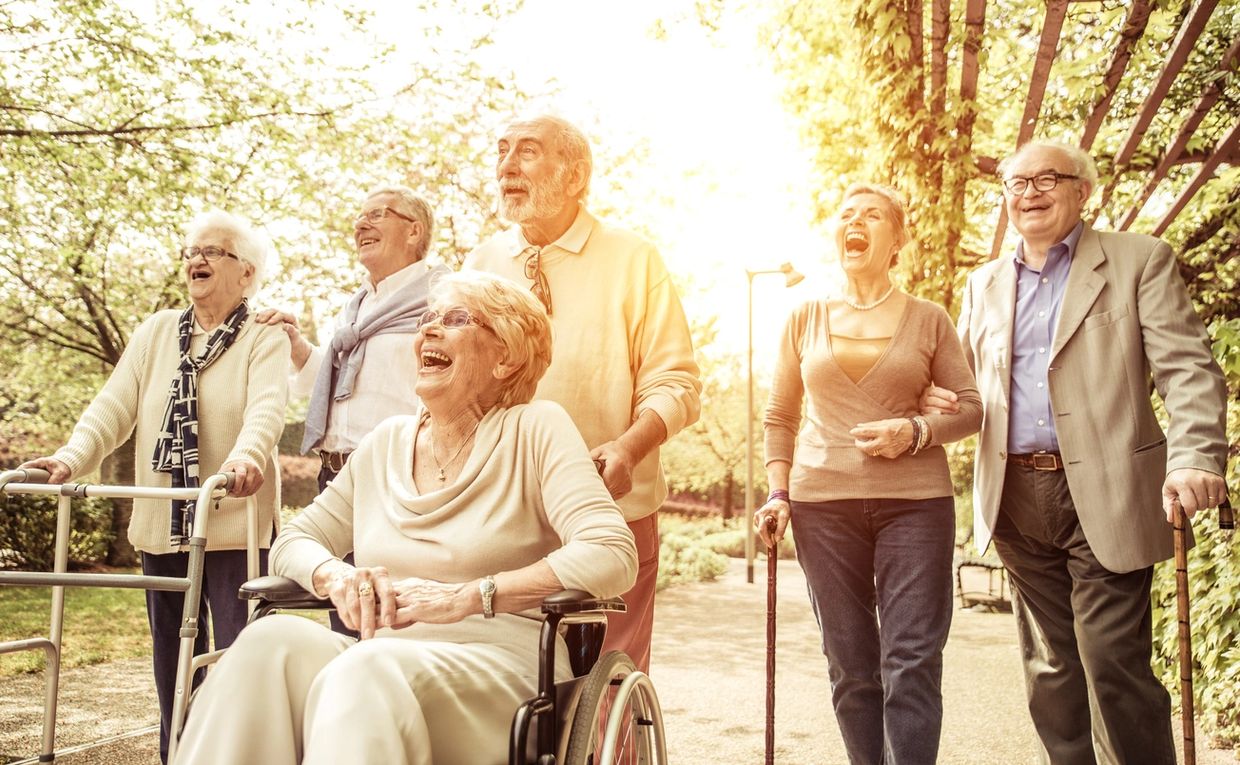 Group of elderly friends enjoying a sunny walk together outdoors.