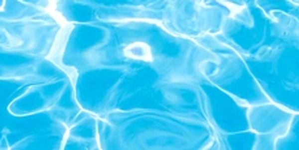 Clear blue water with sunlight reflections creating ripples.