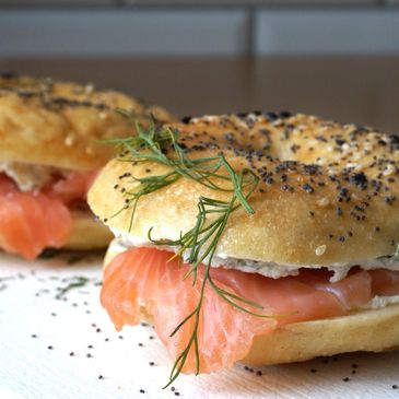 Poppy seed bagels with smoked salmon and cream cheese, garnished with dill.