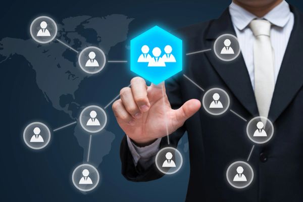 Businessman selecting a digital team network icon on a virtual interface.