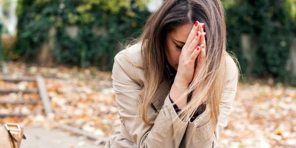 Woman with hands held in front of her face