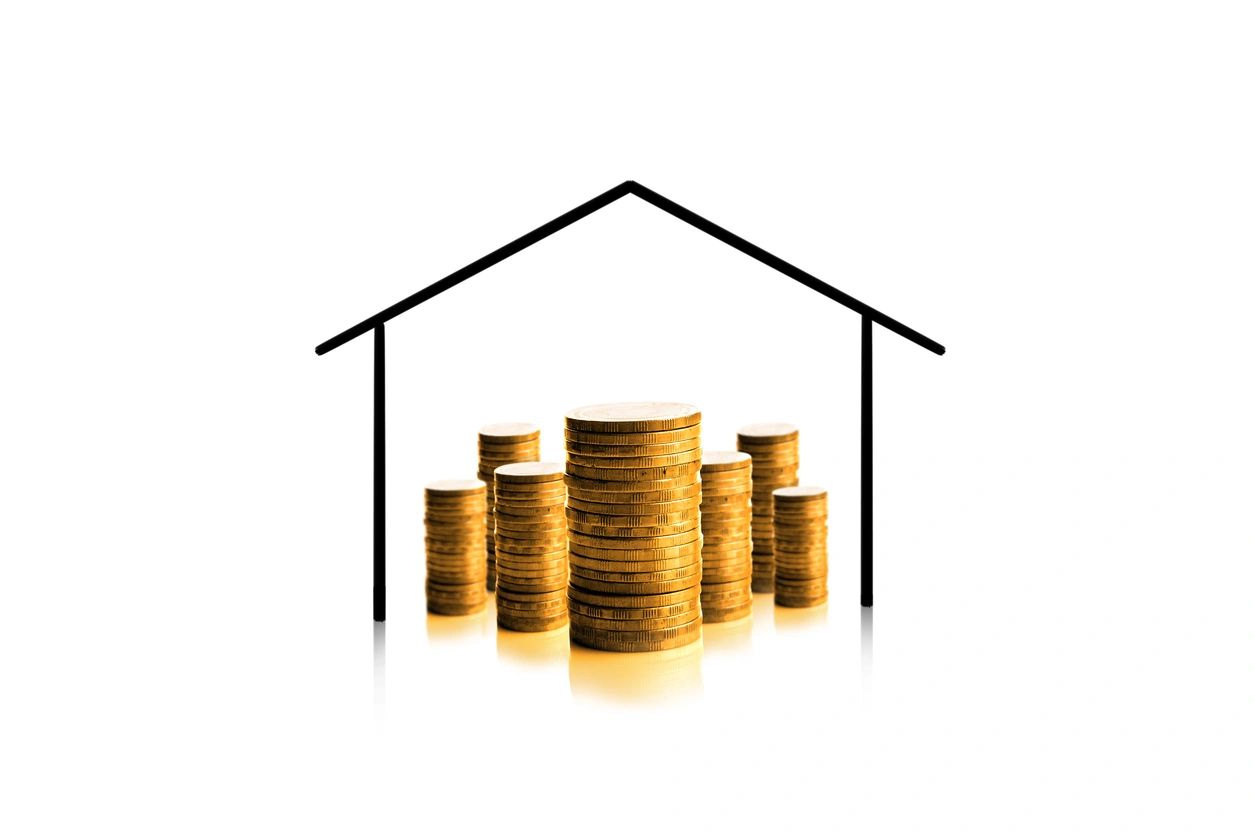 Stacks of gold coins under a house outline symbolizing financial security.
