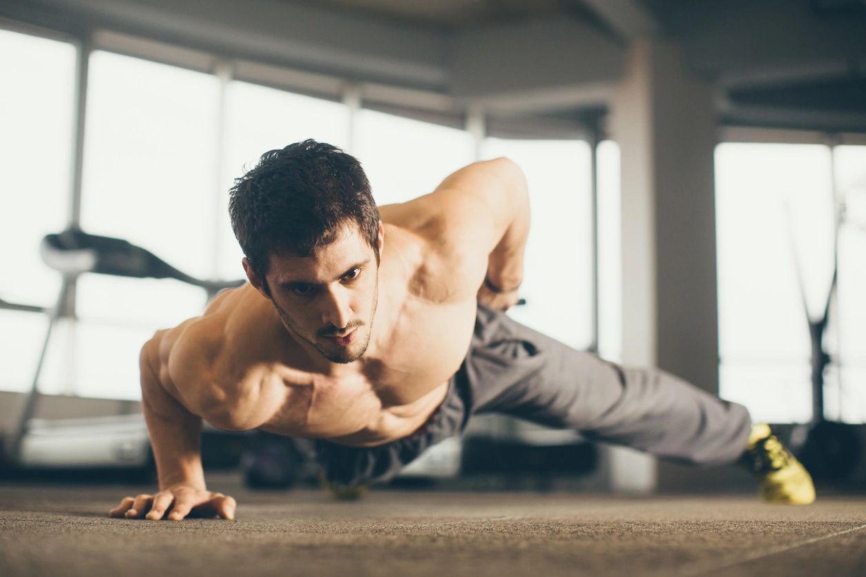A fit man doing single-arm pushups in the gym. Click the link for more information regarding hormone replacement therapy for men and women between the ages of 30 and 65 suffering from low testosterone in Pueblo Colorado.