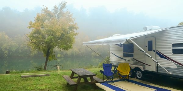 Travel trailer parked at the lake for camping.