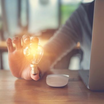 A person holds a glowing light bulb 