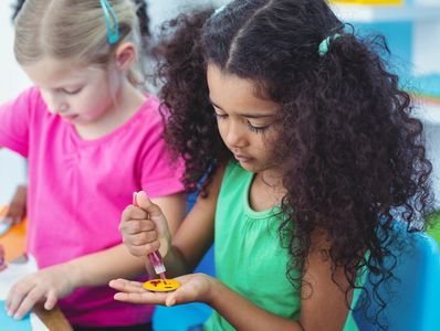 Two young girls making crafts.