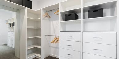 walk in wardrobe in master bedroom with shelving and hangind space