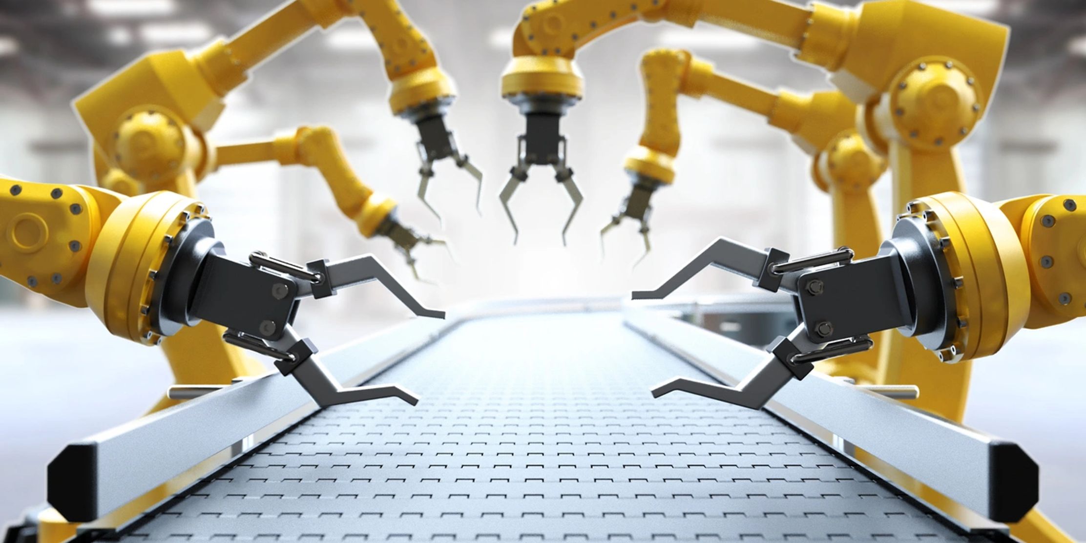 Yellow robotic arms positioned along a conveyor belt in a factory setting.