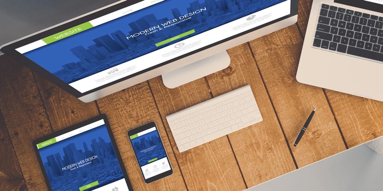 Workspace showing responsive web design on multiple devices including desktop, tablet, and smartphone.