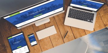 Workspace with desktop, laptop, tablet, and smartphone displaying a website.