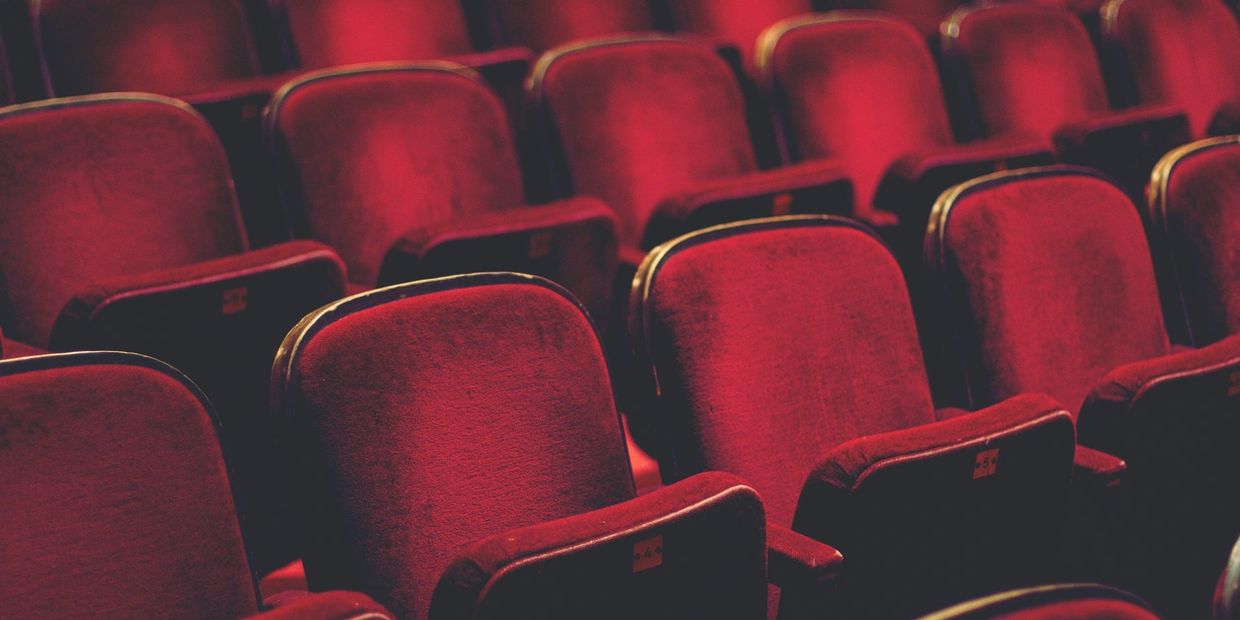 Empty rows of red velvet auditorium seats