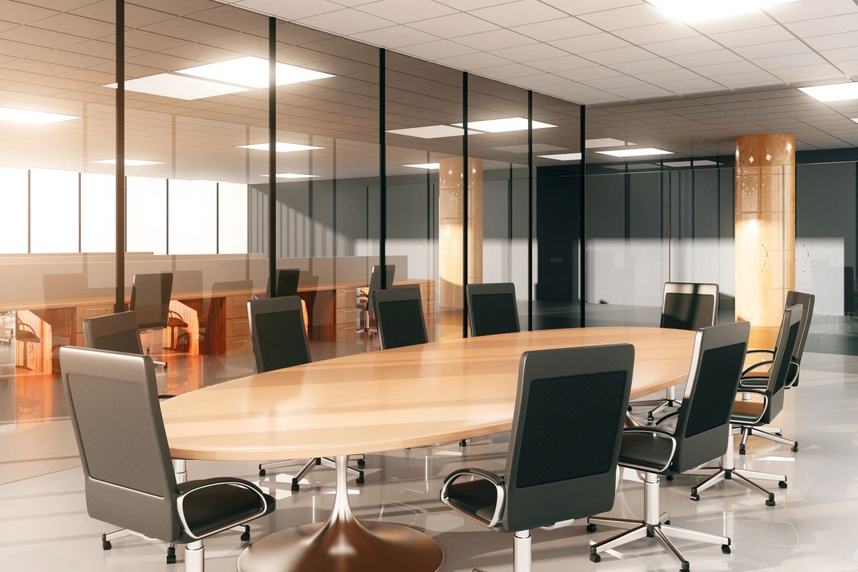 Modern conference room with sleek chairs and a large wooden table.