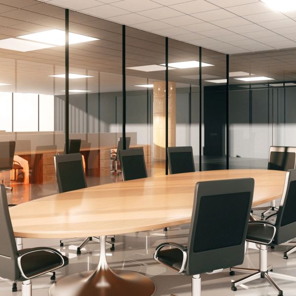 Modern conference room with wooden table and black office chairs.