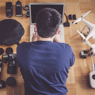 a man sitting, surrounded by drone photography equipment