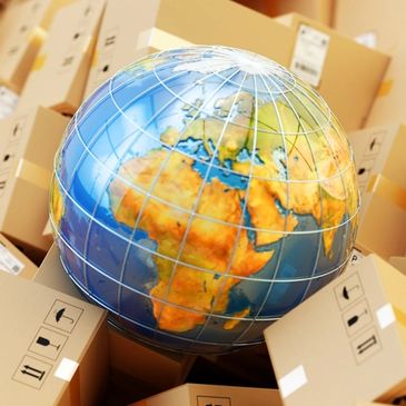 A globe surrounded by stacked cardboard boxes in a warehouse.