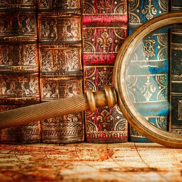 Magnifying glass on old books and map.