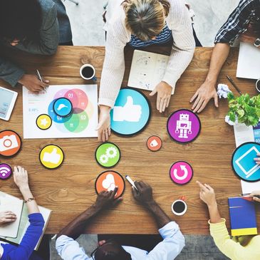 Stock image of people around a table with digitalized symbols