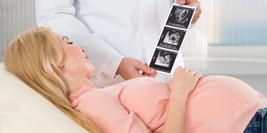 Pregnant woman looking at ultrasound images of a breech baby position.