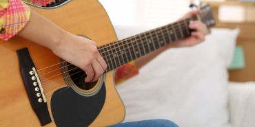 Person playing an acoustic guitar.