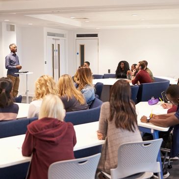 A man Teaching a skill to the student in the classroom