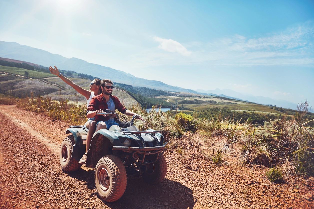 Group riding ATVs on muddy path