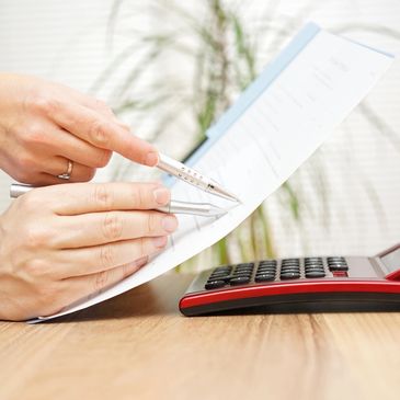 Woman holding a paper and calculator, representing accounting services