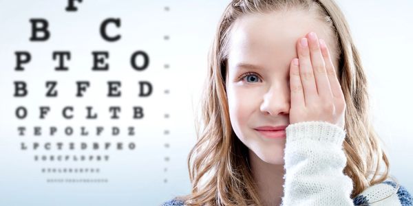 Girl covering one eye for eye exam