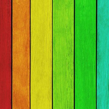 Vertical wooden planks painted in a vibrant rainbow spectrum.