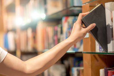 Pulling a book from a library shelf.