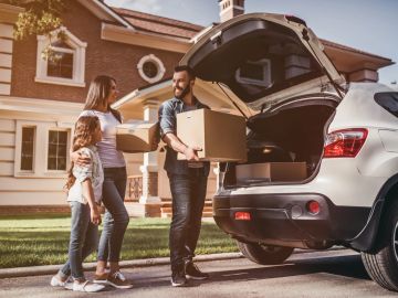 Family loading boxes into car.