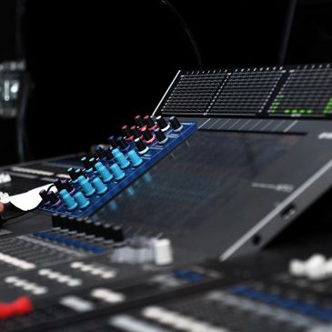 Recording studio, audio mixing board, audio mixer, audio engineer. 