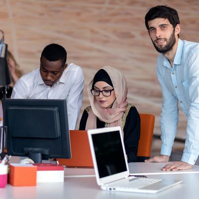 Drie jonge professionals werken samen op kantoor.