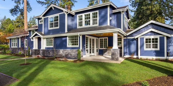 Blue house surrounded by trees.
