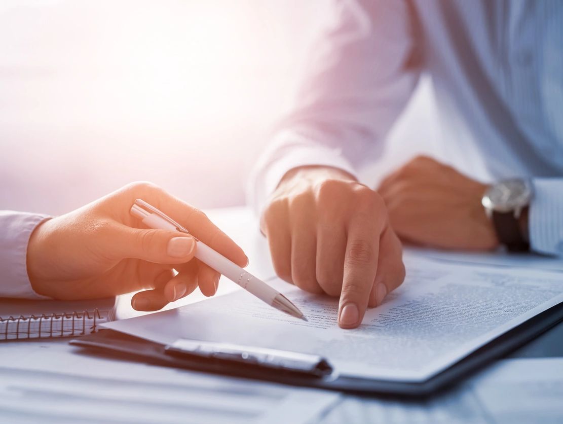 Two people reviewing and discussing a document together.