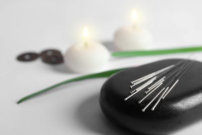 Needles lying on a stone rock used for hot stone massage.
