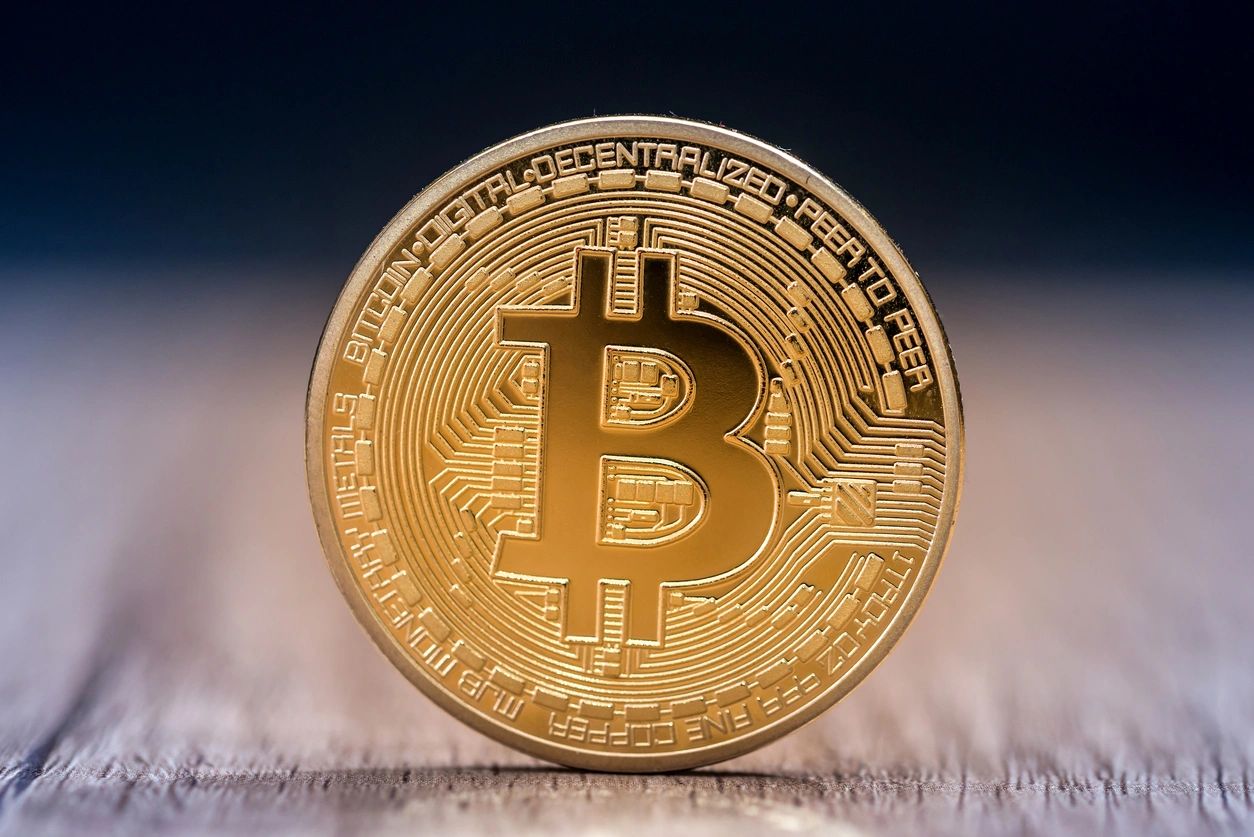 A bitcoin coin on a table.