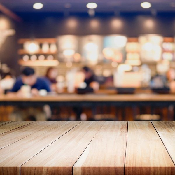 Wooden table surface with a blurred café background.