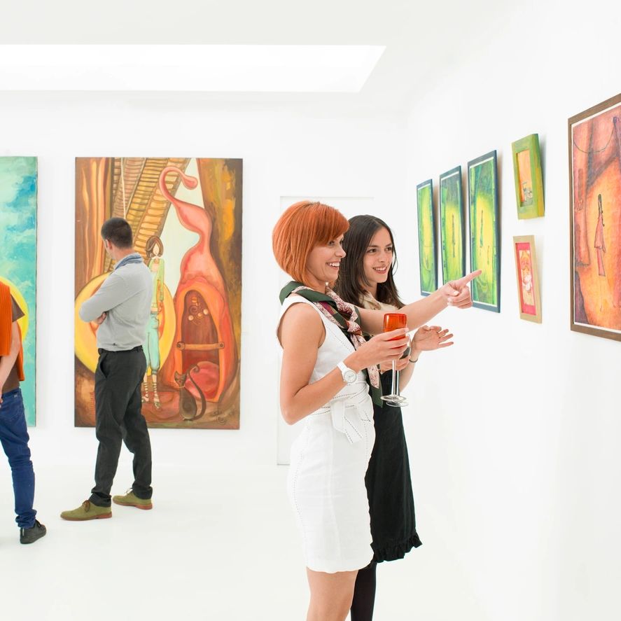 Two women discussing art in a gallery.