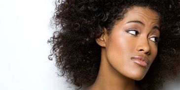 Woman with curly hair looking sideways.