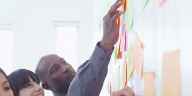 Team collaborating on sticky notes on a wall.