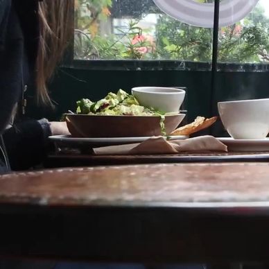 Two people dining with tea and a salad in a cozy cafe setting.