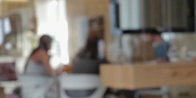 Blurred image of people sitting indoors.
